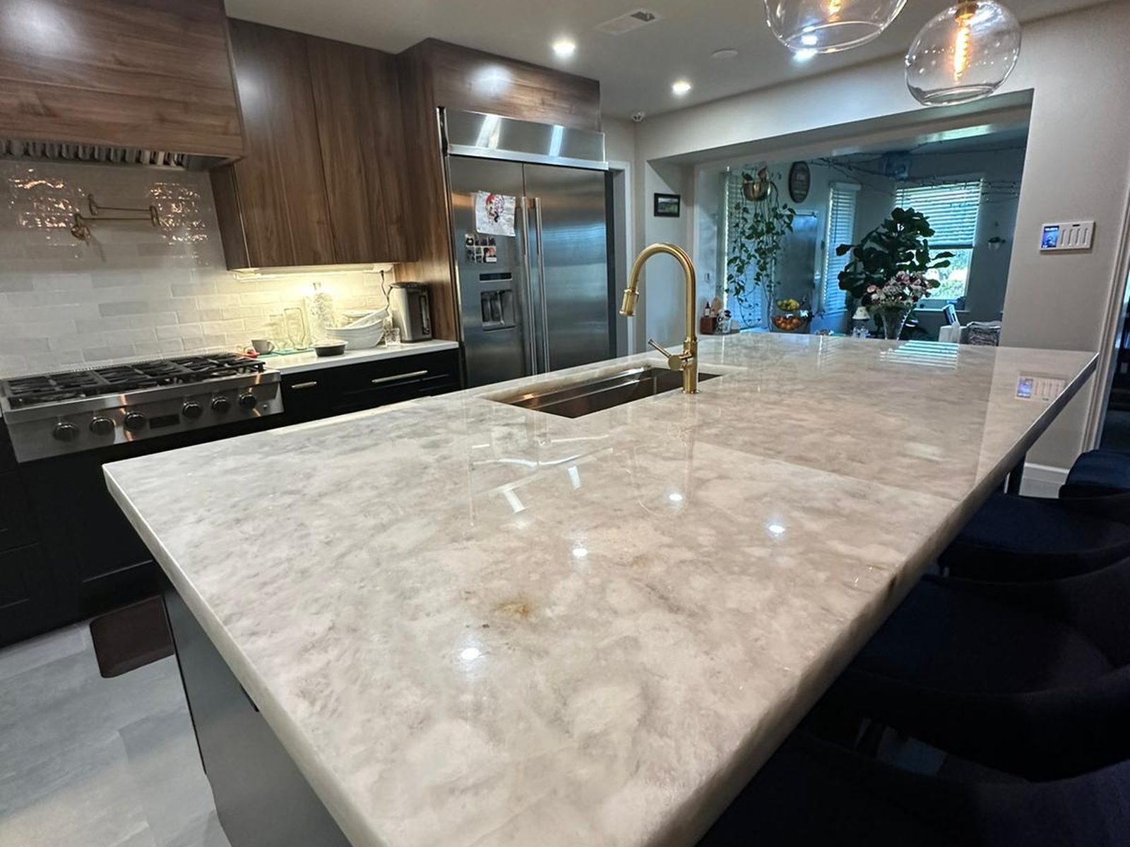 Marble kitchen island countertop with pendant lighting in a remodeled Austin kitchen