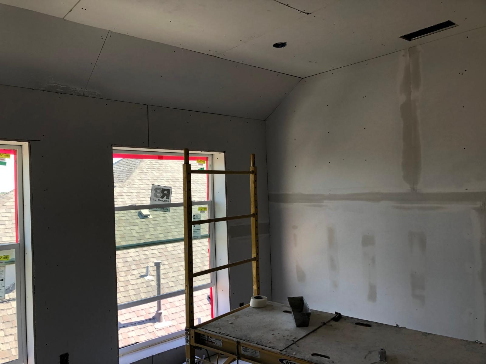 New drywall hung and taped in a room under construction in Austin
